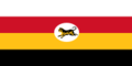 Flag of four stripes along the fly coloured white, red, yellow and black respectively. In the middle is a white oblong circle with a Malayan tiger in it.png